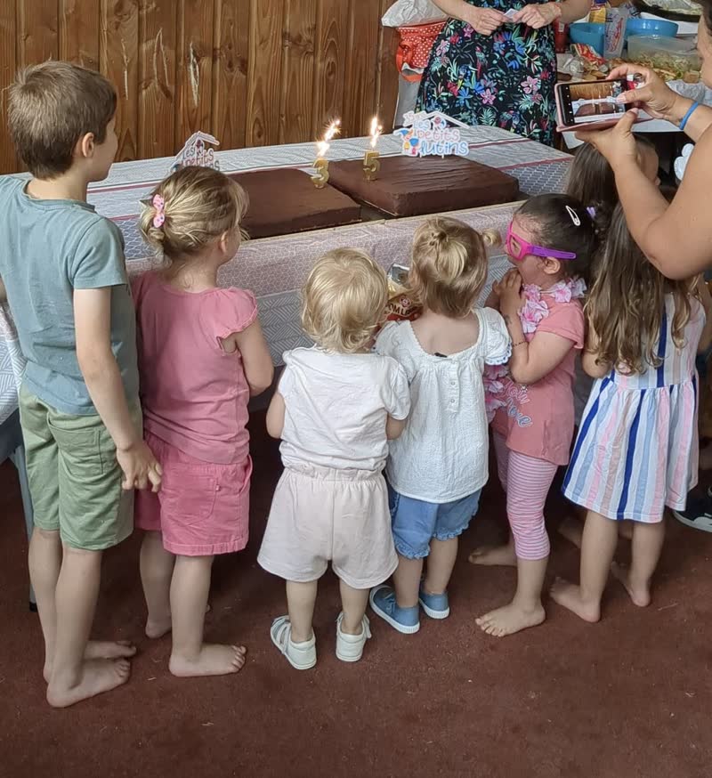 Des enfants regardent un gâteau d'anniversaire avec des bougies