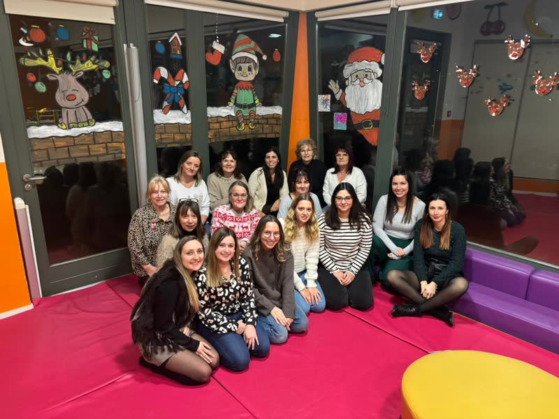 L'équipe de la crèche réunie, assise sur les tapis de la salle de motricité, en décembre 2024