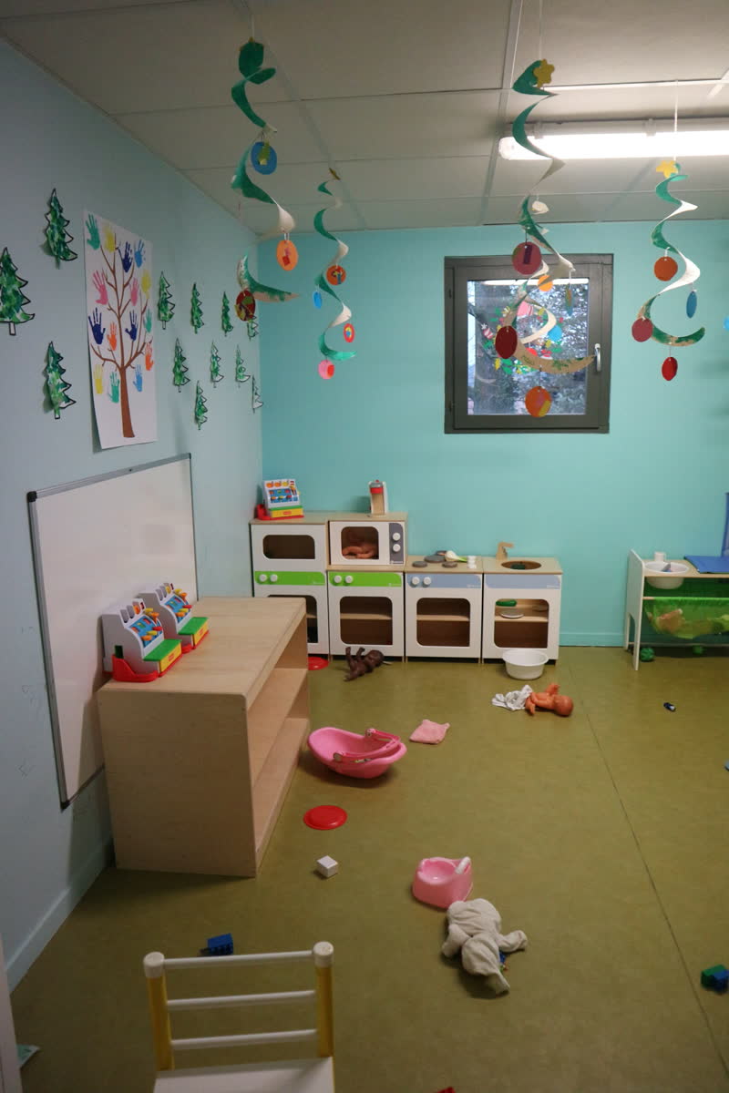 Une salle de jeux aux murs bleus avec une petite cuisine d'enfant et des décorations